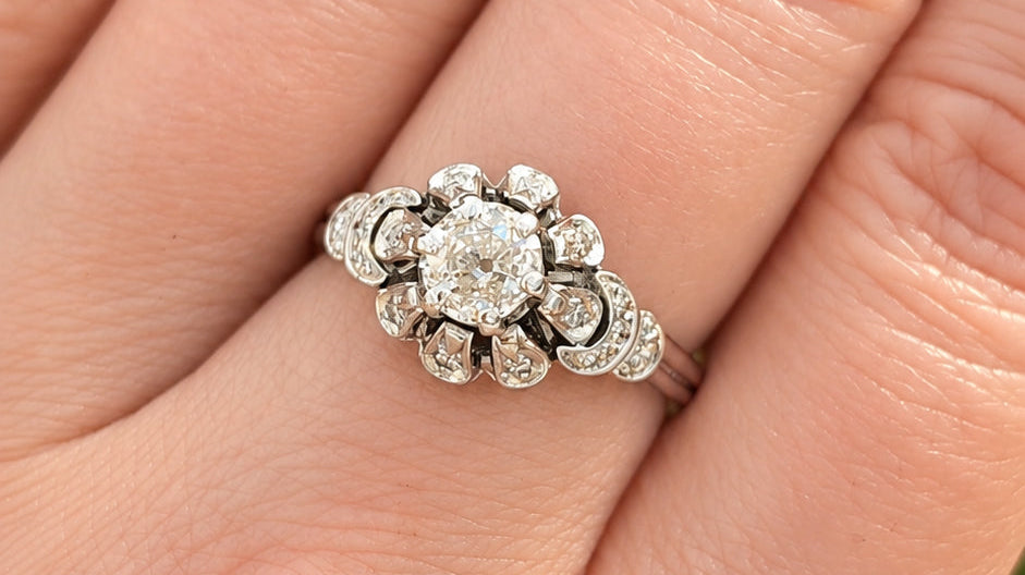 Vintage engagement ring with an old-cut diamond in a floral halo setting.
