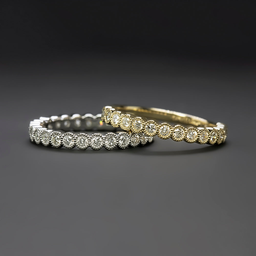 Two elegant diamond bands in white gold and yellow gold, featuring intricate milgrain detailing and sparkling stones.
