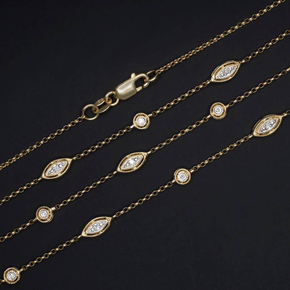 Vintage diamond station necklace in 14k yellow gold, featuring round and marquise diamond settings on a dainty chain.