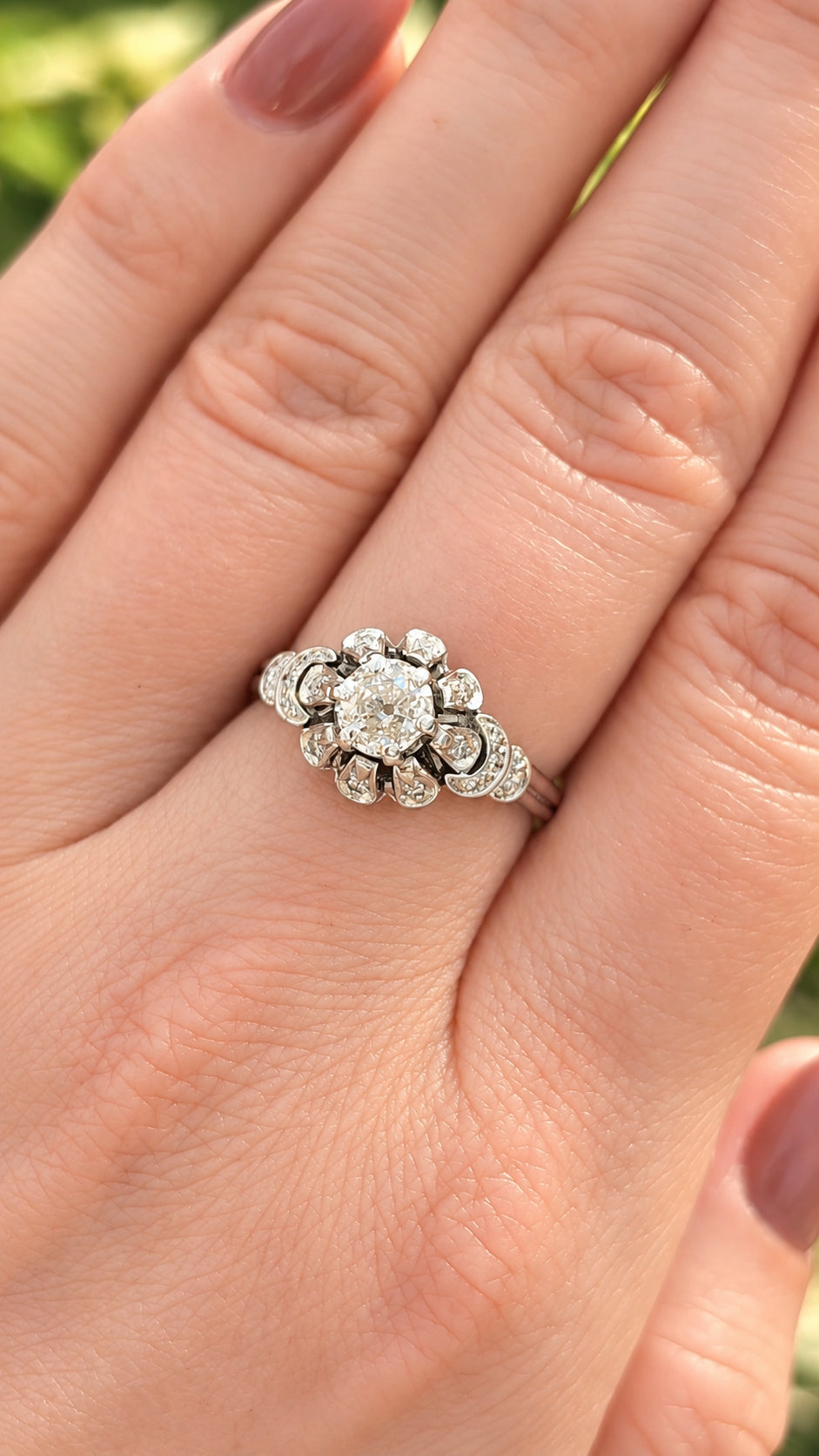 Vintage engagement ring with an old-cut diamond in a floral halo setting.