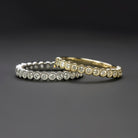 Two elegant eternity bands showcasing natural diamonds in 14k white gold and yellow gold settings.