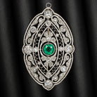 Art Deco vintage pin pendant featuring a green emerald and old cut diamonds in intricate platinum filigree design.