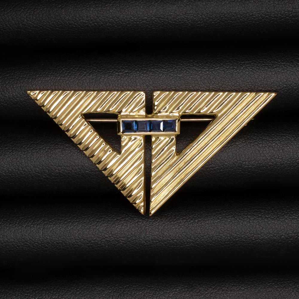 Vintage Tiffany and Co 18k yellow gold brooch with natural blue sapphires in arrow design, weighing 13.8 grams.