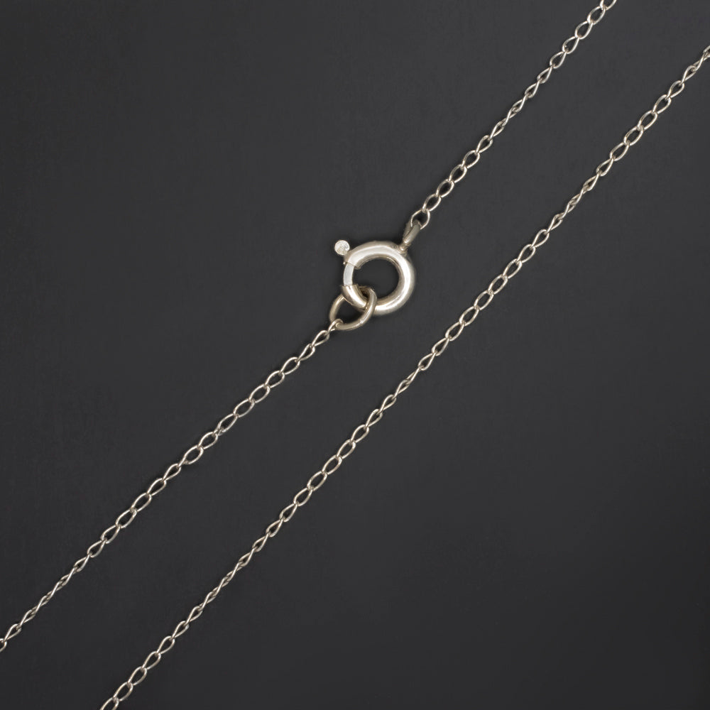 close-up of 14k white gold dainty chain clasp for pearl flower pendant necklace on dark background